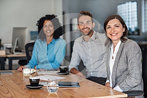 Smiling businesspeople sitting together at an office table