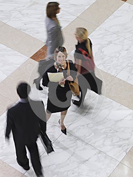 Smiling Businesswoman Amid Blurred Walking People