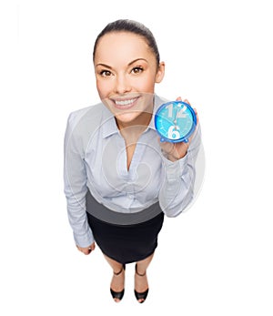 Smiling businesswoman with blue clock