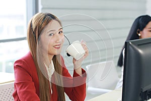 Smiling businesswoman Call Center hand holding a cup of hot coffee. Technical Support staff or receptionist phone operator