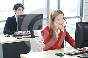 Smiling businesswoman Call Center or Technical Support staff or receptionist phone operator teamwork. Asian customer support team