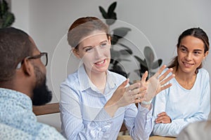 Smiling businesswoman, coach holding briefing with diverse employees