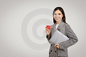 Smiling businesswoman with coffee and laptop in jacket, free space