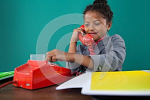 Smiling businesswoman dialing numbers on land line phone