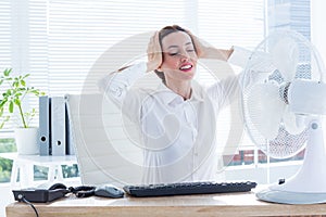 Smiling businesswoman before the fan