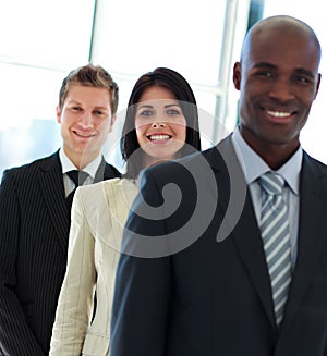 Smiling businesswoman in focus with her team in a