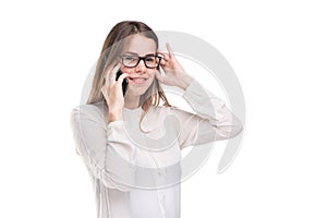 Smiling businesswoman in glasses talking on mobile phone. Beautiful young girl in white shirt on white isolated background talking