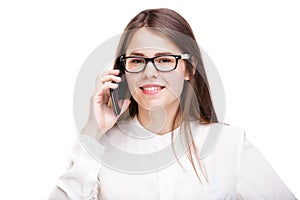 Smiling businesswoman in glasses talking on mobile phone. Beautiful young girl in white shirt on white isolated background talking