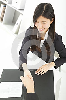 Smiling businesswoman handshaking with businessman