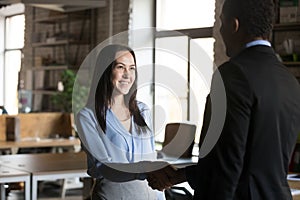 Smiling businesswoman handshaking with executive, getting job or reward