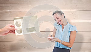 Composite image of smiling businesswoman having a phone call and taking notes