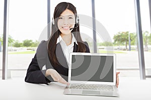 Businesswoman with headset and laptop in the office