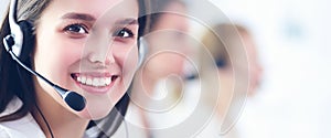 Smiling businesswoman or helpline operator with headset and computer at office