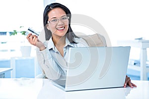 Smiling businesswoman holding credit card