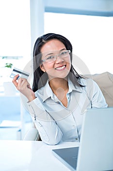 Smiling businesswoman holding credit card