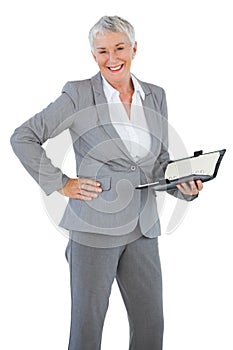 Smiling businesswoman holding diary with her hand on hip