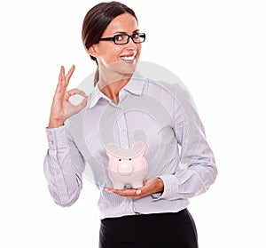 Smiling businesswoman holding pink piggy bank