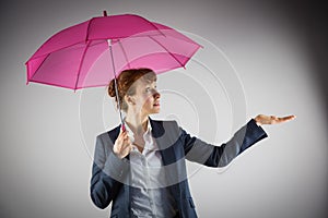 Smiling businesswoman holding pink umbrella