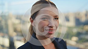 Smiling businesswoman looking camera at morning terrace city view portrait.