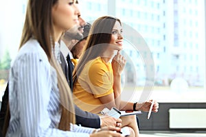 Smiling businesswoman looking at camera at seminar