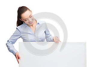 Smiling businesswoman lookint at white blank board