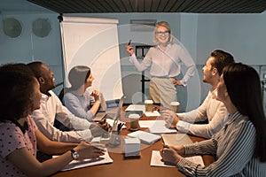 Smiling businesswoman make flip chart presentation at meeting