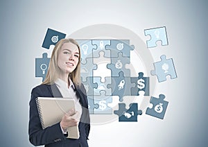 Smiling businesswoman, notebook, business puzzle