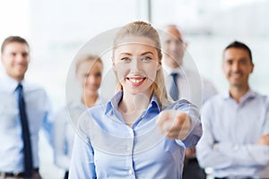 Smiling businesswoman pointing finger on you