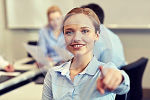 Smiling businesswoman pointing finger on you