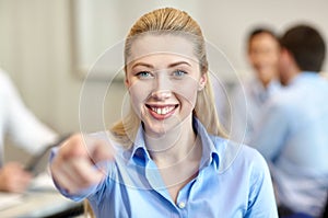 Smiling businesswoman pointing finger on you