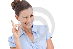 Smiling businesswoman pointing upwards