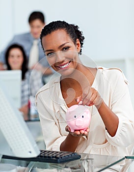 Smiling businesswoman saving money in a piggy-bank