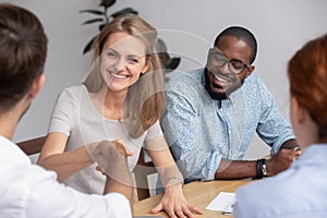 Smiling businesswoman shaking hand of business partner at meeting