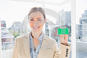 Smiling businesswoman showing green business card