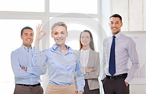 Smiling businesswoman showing ok-sign in office