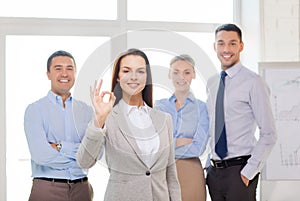 Smiling businesswoman showing ok-sign in office