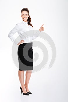 Smiling businesswoman showing thumb up isolated on a white