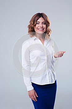 Smiling businesswoman standing over gray background