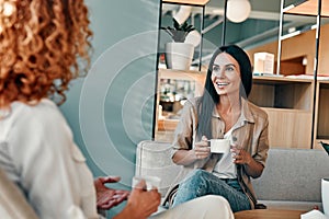 Smiling businesswoman talking with business partner in cafe