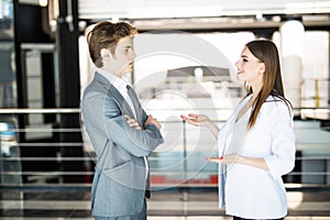 Smiling businesswoman telling something to her colleague in the office. Business man speak with business woman in office