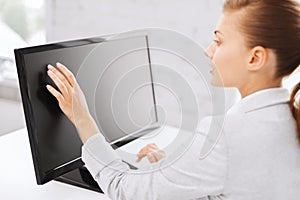 Smiling businesswoman with touchscreen in office