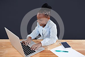 Smiling businesswoman typing on laptop in office