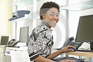 Smiling Businesswoman Using Computer In Office
