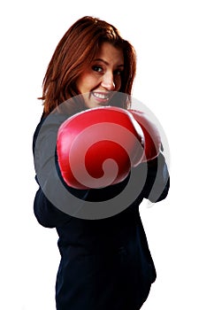 Smiling businesswoman wearing boxing gloves punching