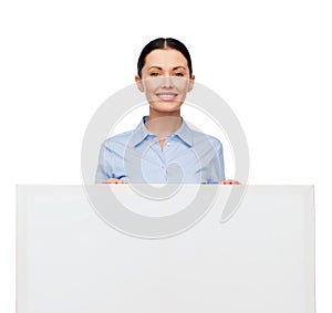 Smiling businesswoman with white blank board