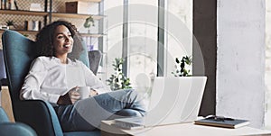 Smiling businesswoman working on laptop computer in office lobby panoramic banner, Young woman professional relaxing at office