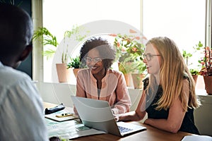 Smiling businesswomen meeting with colleagues in an office board