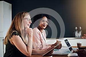 Smiling businesswomen talking with colleagues in an office board