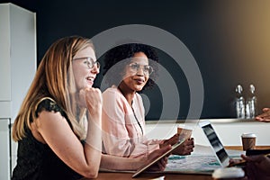 Smiling businesswomen talking with colleagues in an office board photo