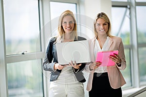 Smiling businesswomen talking and working together in office